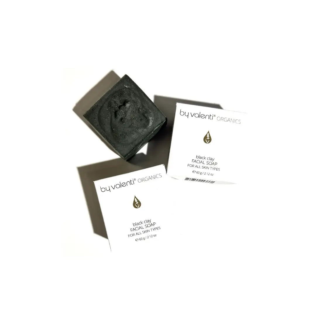 By Valenti boxes of black clay facial soap with packaging on a white background