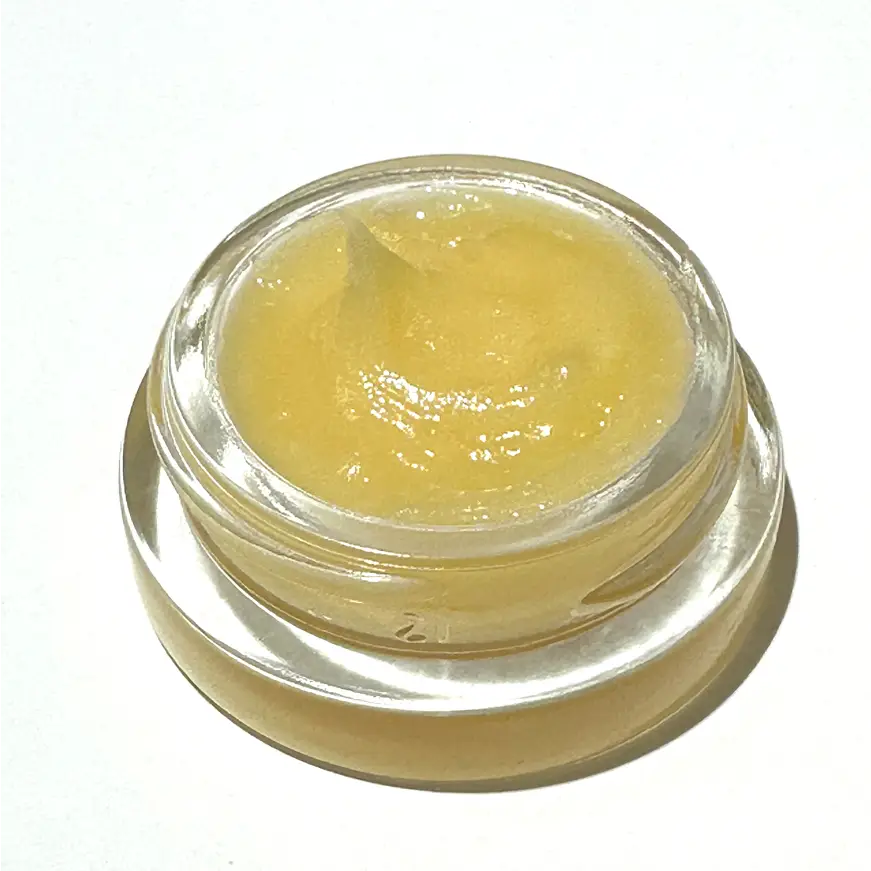 Small clear jar of By Valenti Lip Doctor on a white background