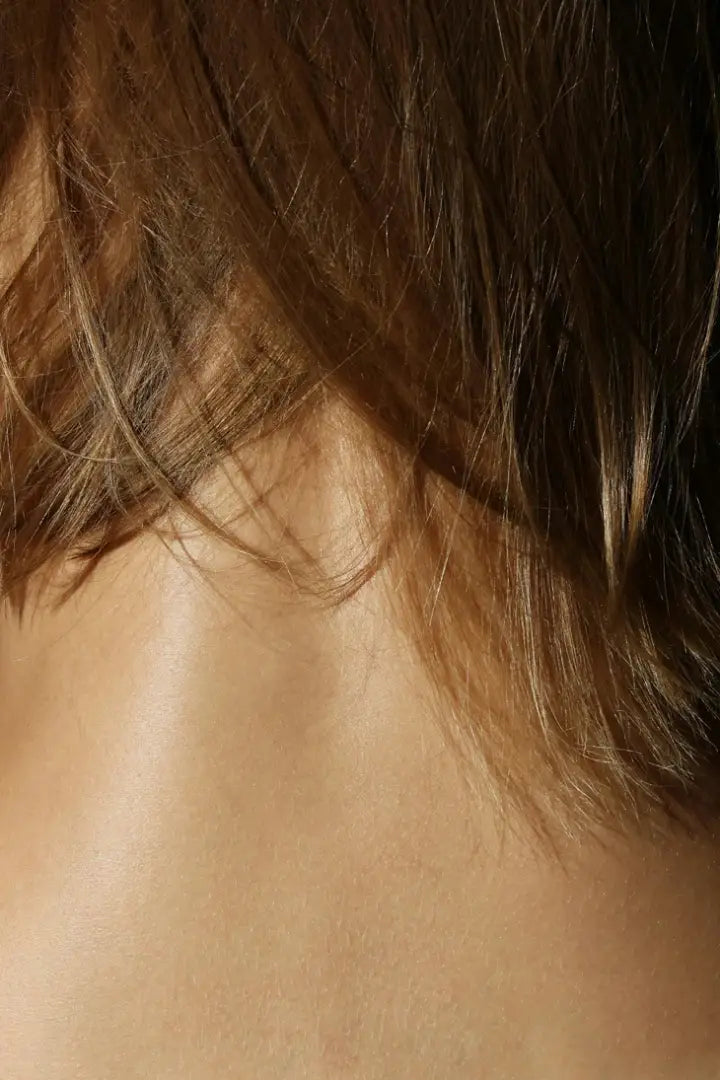 Close-up of a woman's back of neck with hair partially covering it